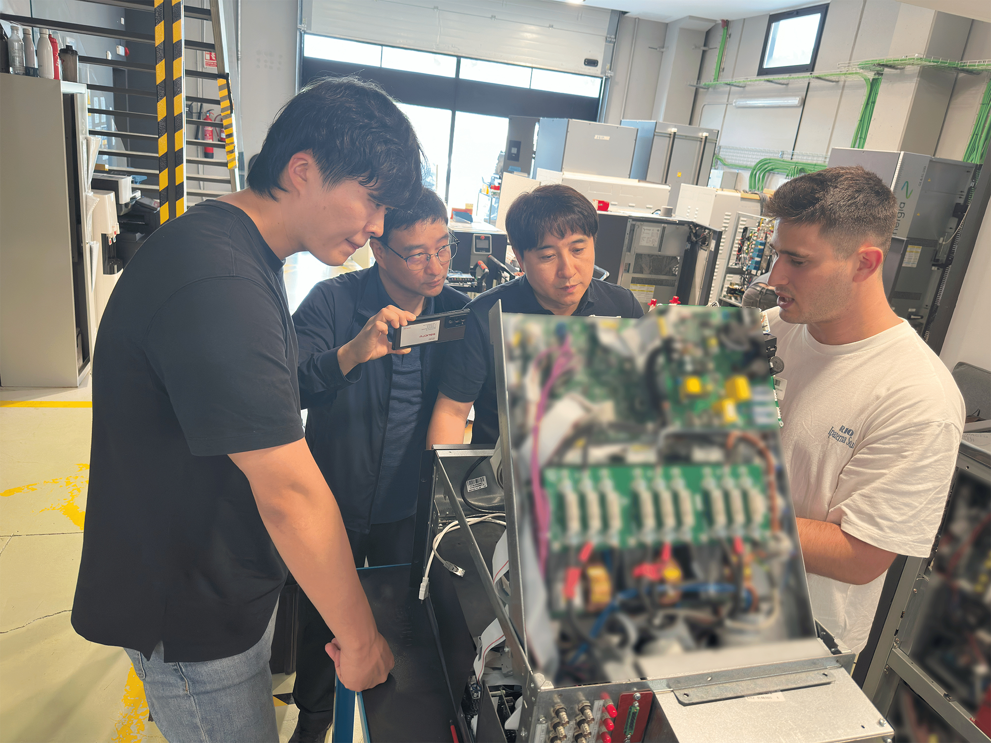 Close-up of KMi engineers and Cinergia’s technician working together on product maintenance tasks.